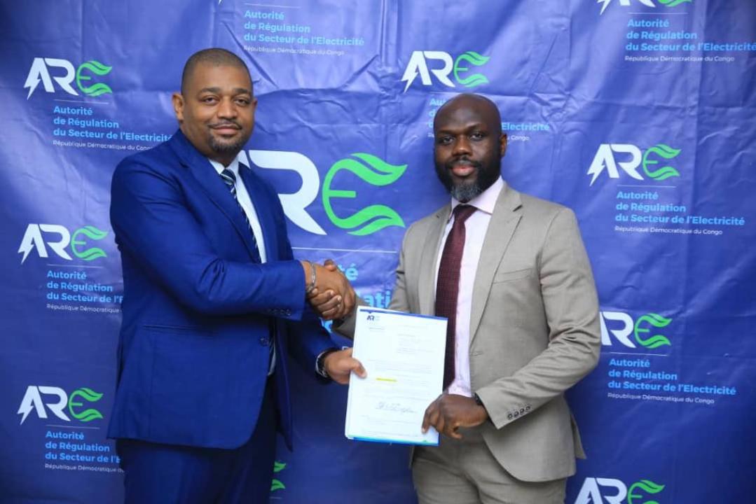 Le Dir. executif de MIGHTY LAND Serge Mukendi recevant les documents de l'aval des travaux auprès du DGA de l'ARE Marco Kuyu