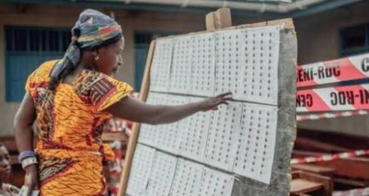 Une dame devant la liste provisoire des électeurs, lors des élections de 2018