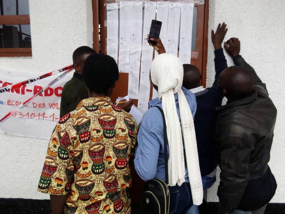 Des témoins consultant les résultats de leurs élus au Centre de vote Les Volcans