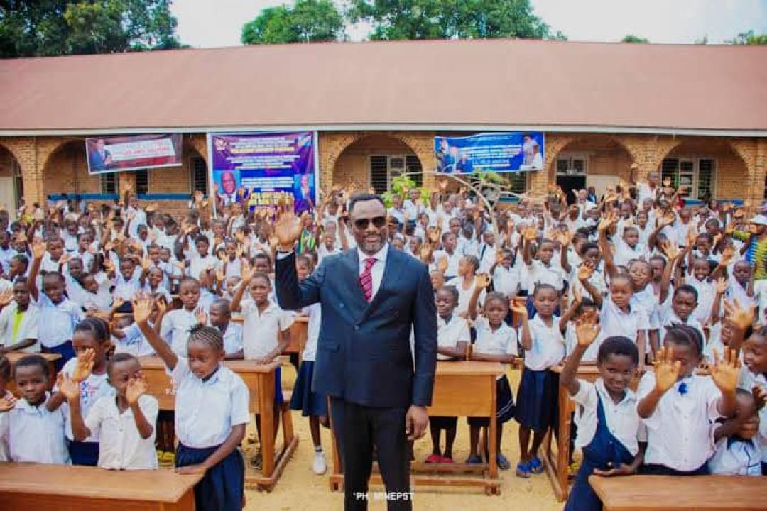Ministre de l'EPST Tony Mwaba et les élèves lors d'une séance de remise des bancs dans les écoles de Kinshasa.
