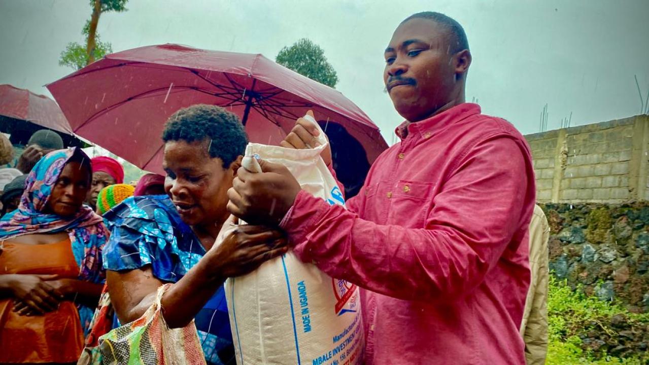 Espoir Mwimuka, activiste des droits de l'homme est en train de remettre un sac de farine à une femme déplacée [photo d'illustration]