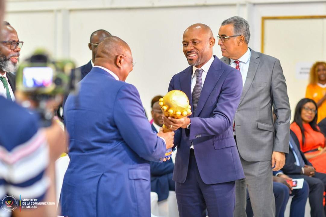 Le porte-parole du Gouvernement ivoirien Amadou Coulibaly remettant le trophée de la CAN remporté par son pays à son homologue rd-congolais Patrick Muyaya Katembwe