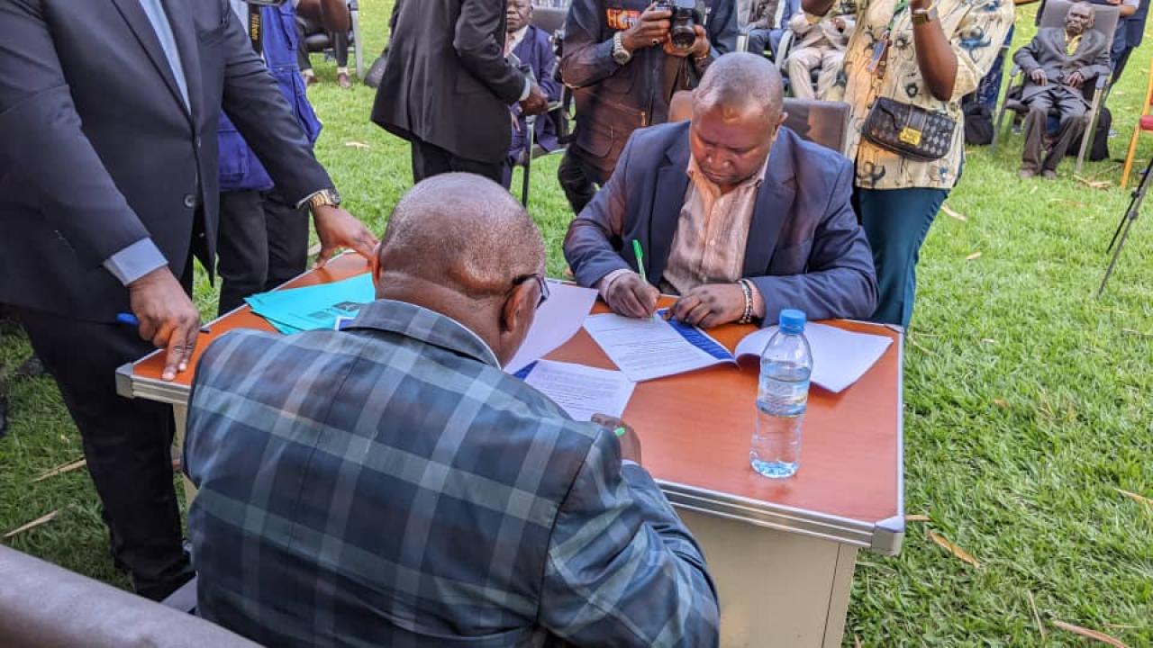 De gauche à droite, Kaviti Herman et Bimenyimana Samvura signent un accord de cohabitation pacifique entre les communautés Hutu et Nande au Nord-Kivu