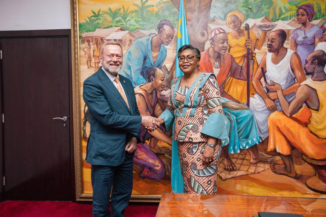 Poignée de main entre la Première Ministre Judith Suminwa Tuluka et le ministre britannique des Affaires Étrangères  pour l'Afrique, Lord Ray Collins