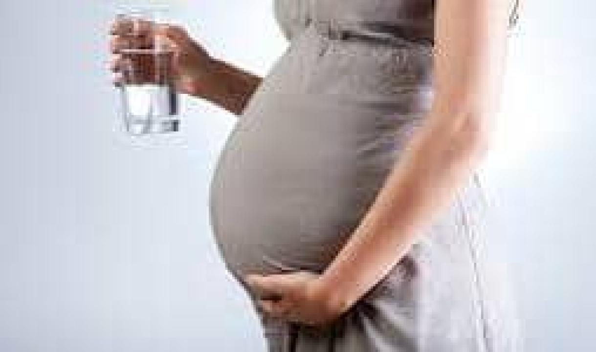 Une femme enceinte qui prend de l'eau [photo d'illustration]