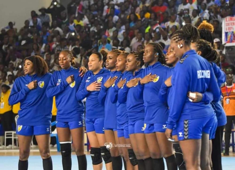 L'équipe féminine des Léopards handball entonnant l'hymne national avant un match au gymnase du stade des martyrs.