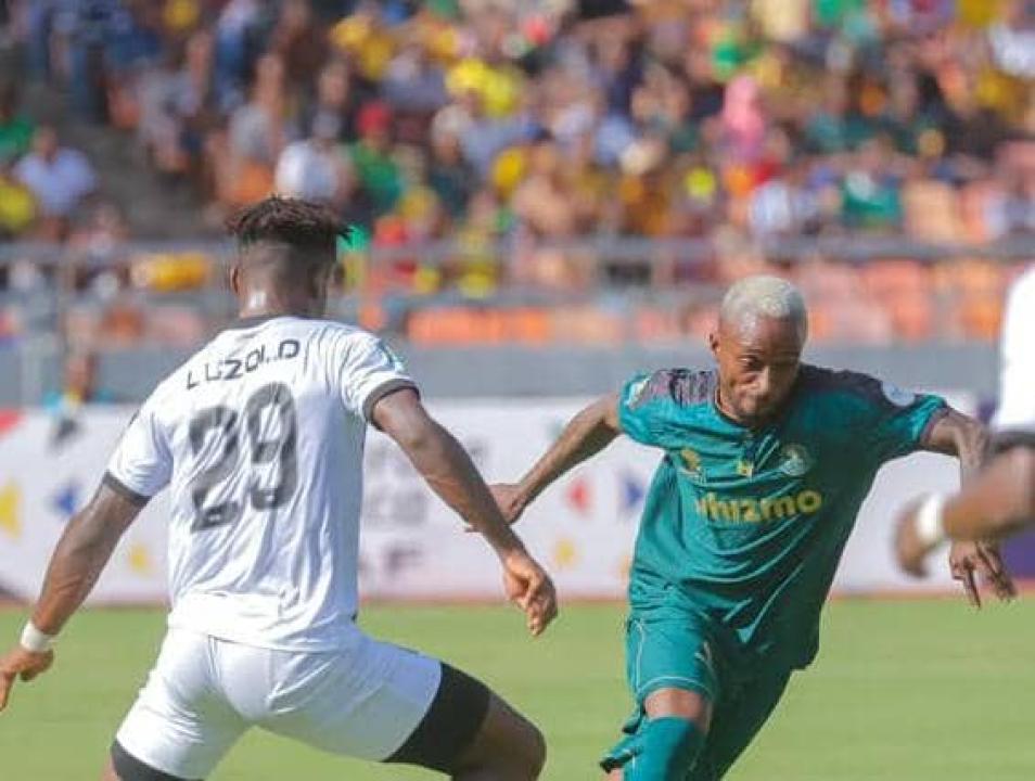 Le défenseur de Mazembe, Ernest Luzolo en duel avec un joueur de Young Africans.