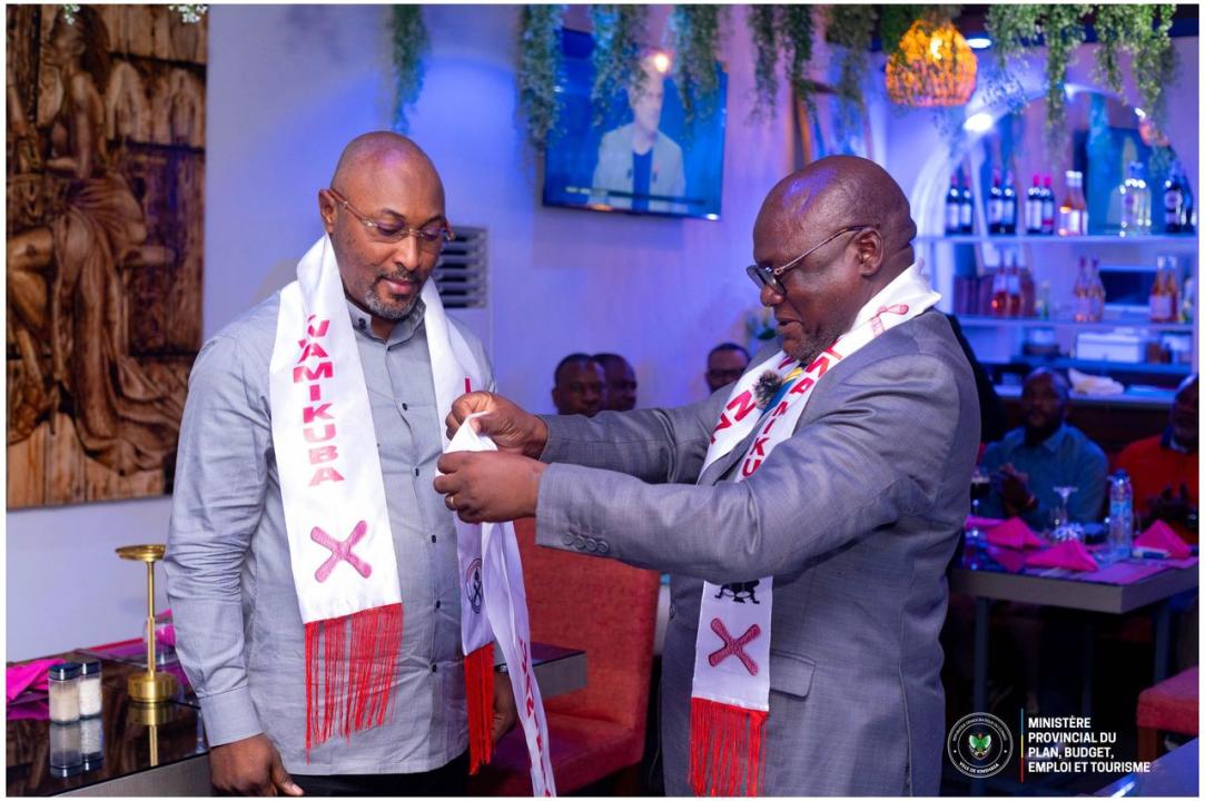 Jésus-Noël Sheke en chemise grise portant l'écharpe estampillée Lwanzo Lwamikuba
