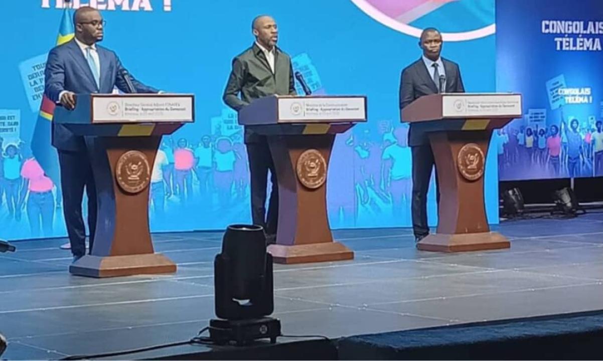 Le ministre de la Communication et Médias Patrick Muyaya, entouré du DGA de FONAREV, Kevin Ngunga Makiedi à sa gauche et du Professeur Serge Mayaka, membre de la coordination du comité scientifique préparation de la table ronde sur la GENOCOST