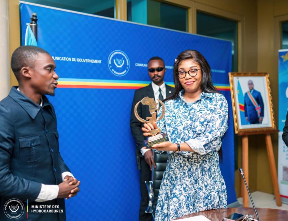 Acacia Bandubola, ministre des Hydrocarbures et le chef de la délégation de l'Association Jeunesse 242, lors de la remise du trophée et le diplôme de mérite.