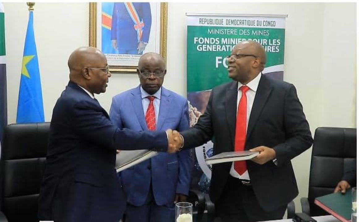 Poignet de main entre le DG sortant Faustin Biringanine et celui entrant Godard Motemona lors de la cérémonie de remise et reprise