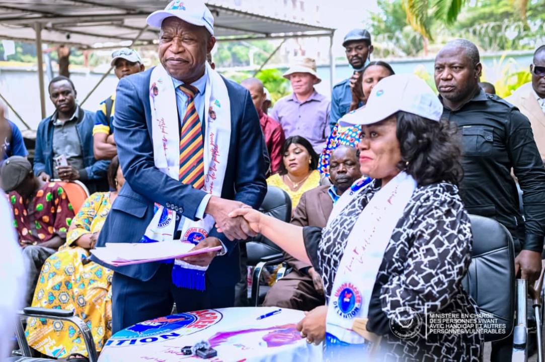 Poignée de main entre Irène Esambo, ministre déléguée en charge des PVH-APV, et le Secrétaire permanent de l'Union Sacrée de la Nation, André Mbata
