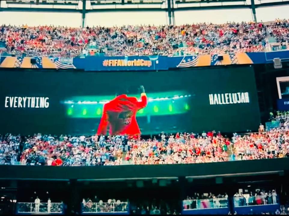 L’image de Lumumba Vea, bras levé, en hommage à Patrice Lumumba, projetée sur les écrans géants du stade lors d’une prestation à la mi-temps de la finale de la Coupe du monde 2026