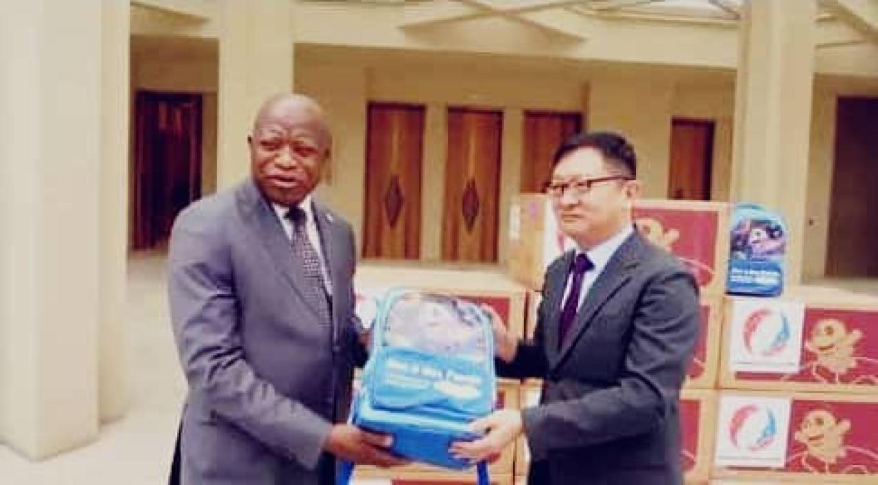 L’ambassadeur de Chine en RDC et le secrétaire permanent de l’USN, le professeur André Mbata, présentent un kit scolaire destiné aux élèves congolais.