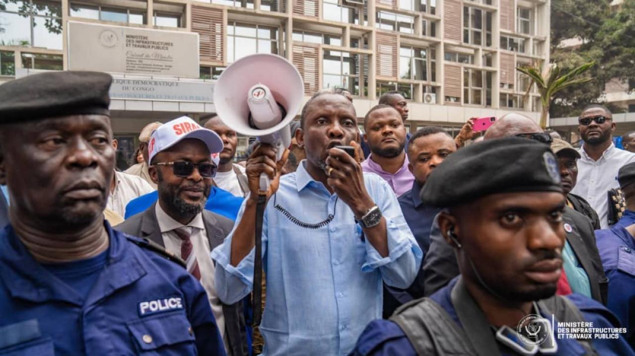Le ministre des Infrastructures et Travaux publics, John Banza, s’adressant aux agents de son ministère au moyen d’un mégaphone afin de les rassurer quant à leurs revendications sociales