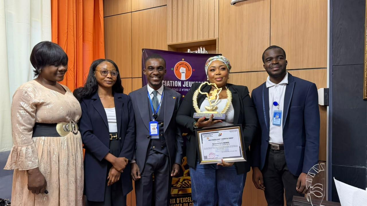 Rachel Kitsita Ndongo, directrice générale d’Actu30 TV, pose avec son diplôme de mérite aux côtés des membres de l’Association Jeunesse 242.