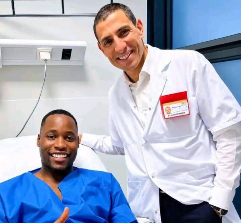 Lionel Mpasi sur un lit d'hôpital après les examens sur sa blessure