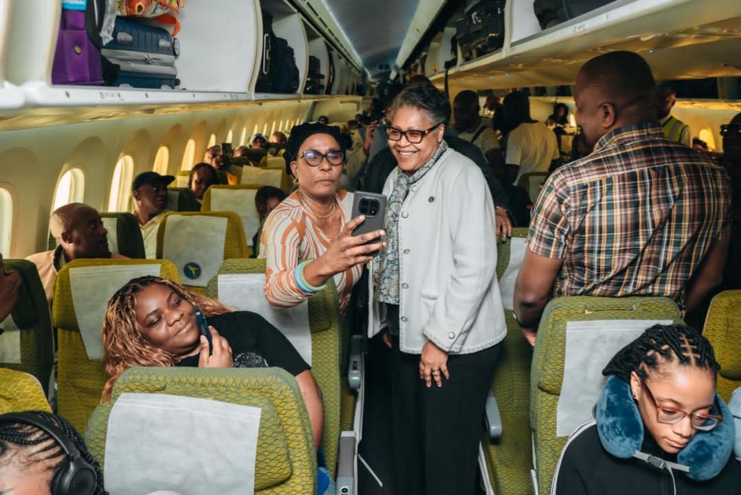 À bord de l’Airbus A330-900 d’Air Congo, la Première ministre Judith Suminwa Tuluka affiche un large sourire aux côtés d’autres passagers et se réjouit de la qualité du service à bord de la compagnie nationale, sur le chemin de New York.