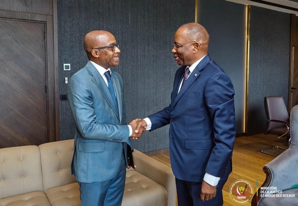 Poignée de mains entre Patrice Vahard, Directeur pays du BCNUDH en RDC (à gauche) et Guillaume Ngefa, ministre de la Justice et Garde des Sceaux en RDC (à droite)